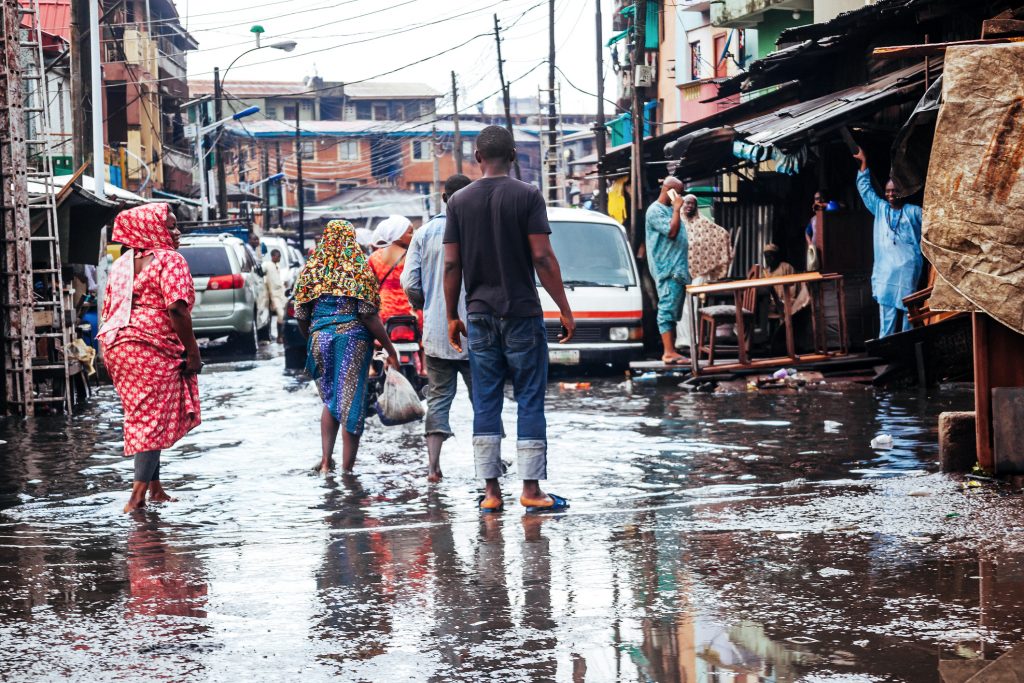Lagos, Nigeria: Rainy season in African city - everyday traffic in flooded market streets in city center.