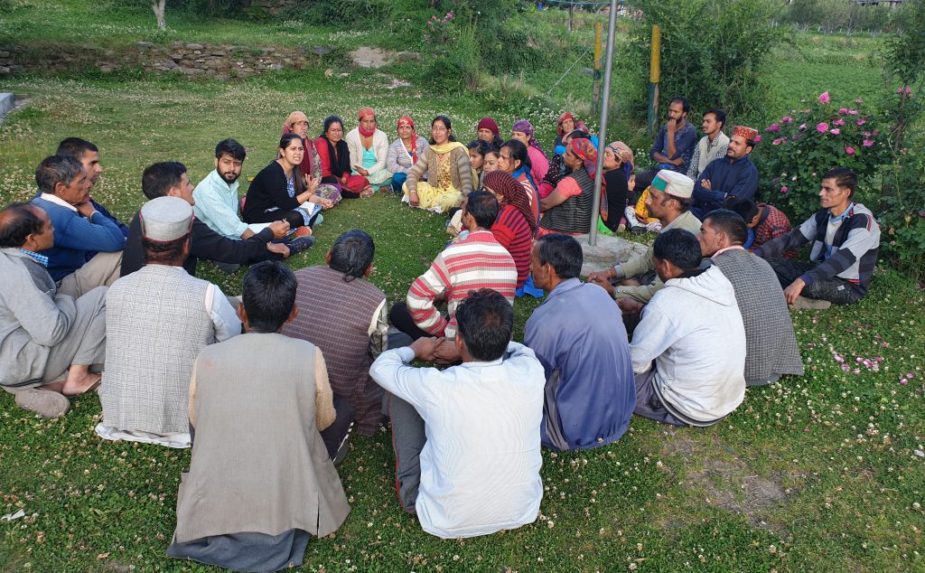 group of Indian farmers seated in a circle.