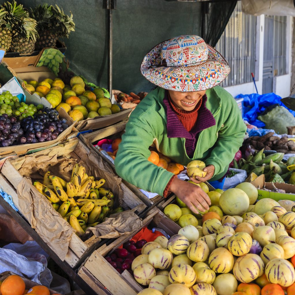 Femme péruvienne autochtone vendant des fruits sur un marché