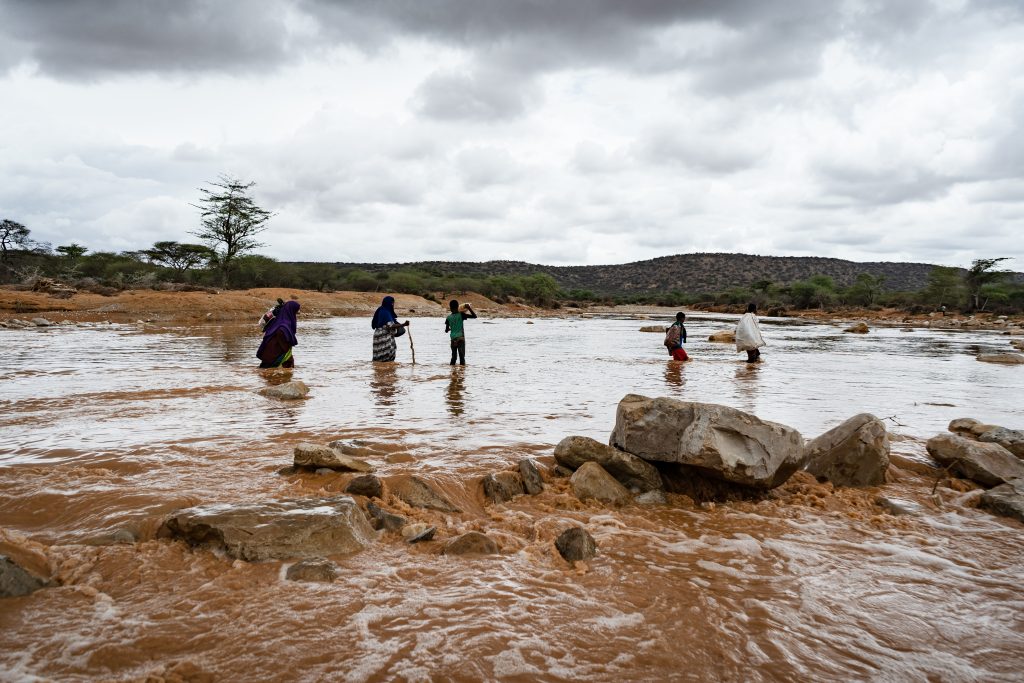 Familia somalí cruzando un río debido a una inundación repentina que siguió a fuertes lluvias. Bokolmayo, Dollo Ado, región de Somalia, Etiopía, octubre de 2018.