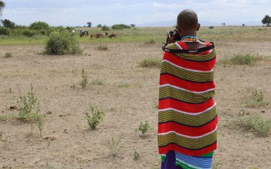 Une mentorée en photographie, Catherine Pilalei, pointe son appareil photo vers le bétail à distance lors d'une session de formation pratique lors d'un atelier sur l'adaptation et la planification au changement climatique à Amboseli, au Kenya. Lensational/ Esther Tinayo (Stagiaire Amboseli)
