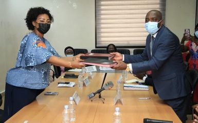 Exchange of signature books between Nassénéba Touré, Minister of Women, Family, and Children, and Jean-Luc Assi, Minister of the Environment and Sustainable Development.