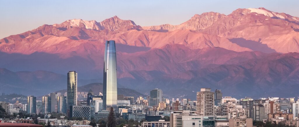 Aerial view of Santiago skyline at sunset with Costanera skyscraper and Andes Mountains - Santiago, Chile